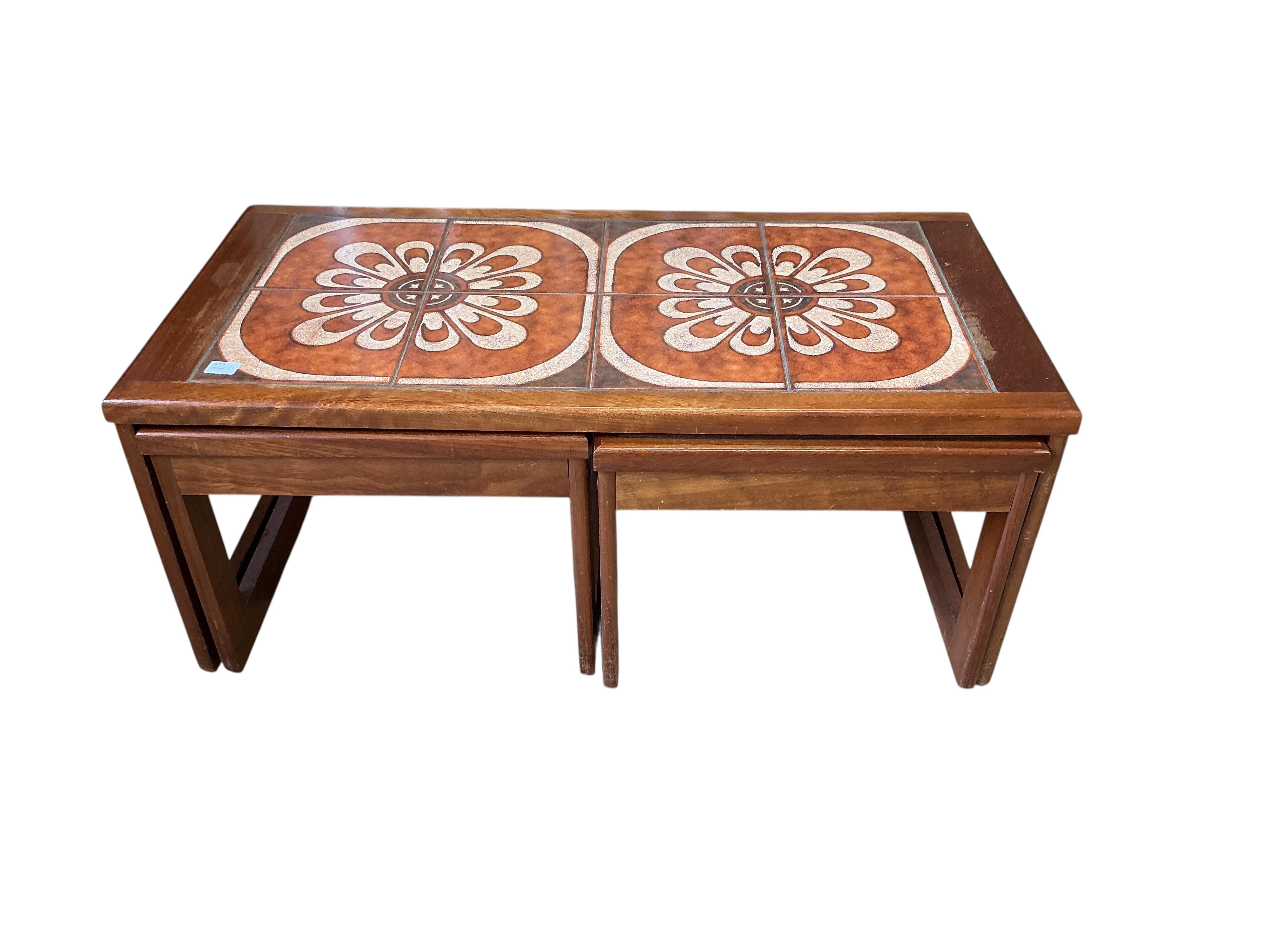 A nest of three mid century tiled top teak tables, width 96cm, depth 48cm, height 40cm
